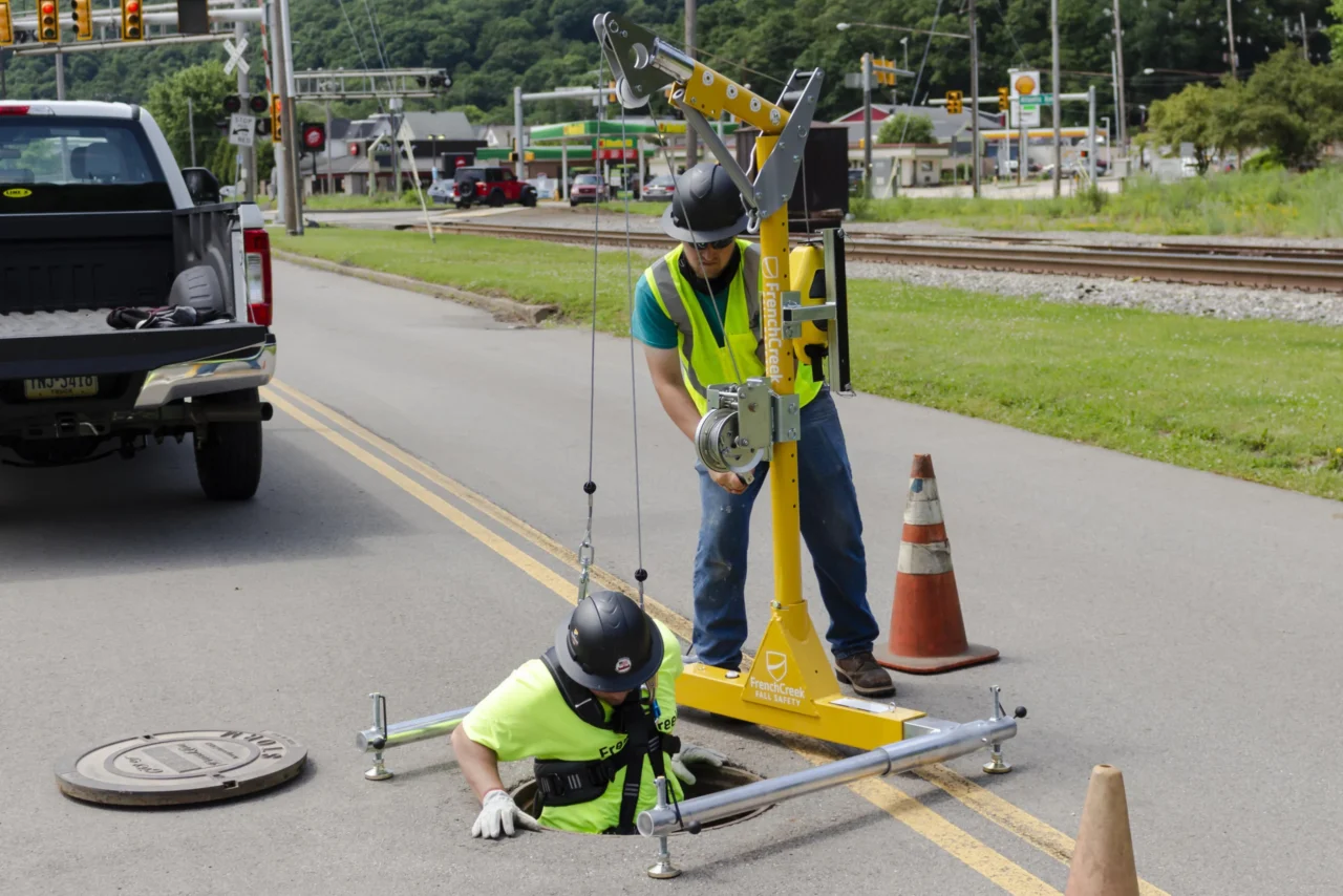 Confined Space Attendant Lowering Worker Into Confined Space