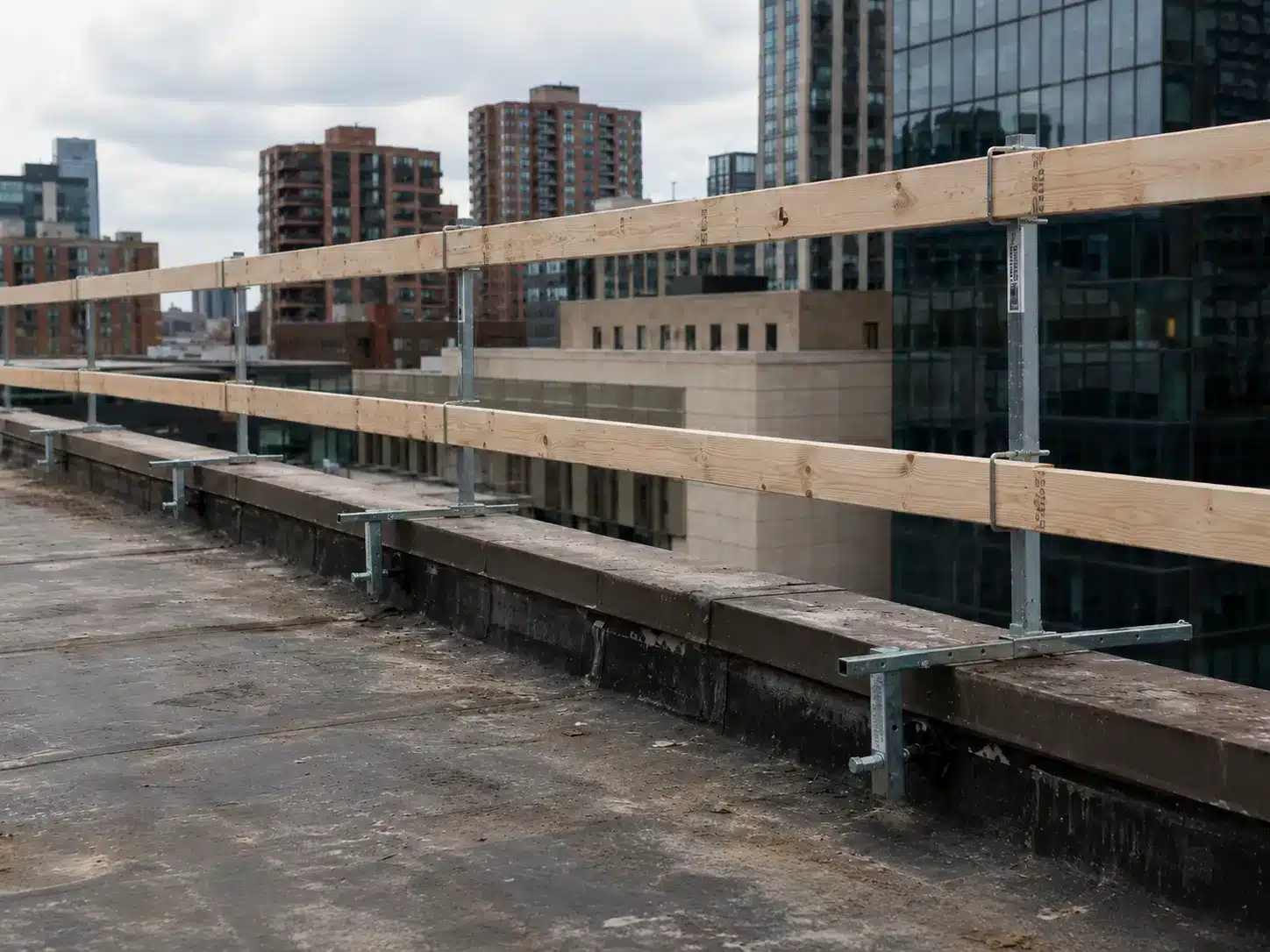 Portable guardrail system installed on a parapet wall