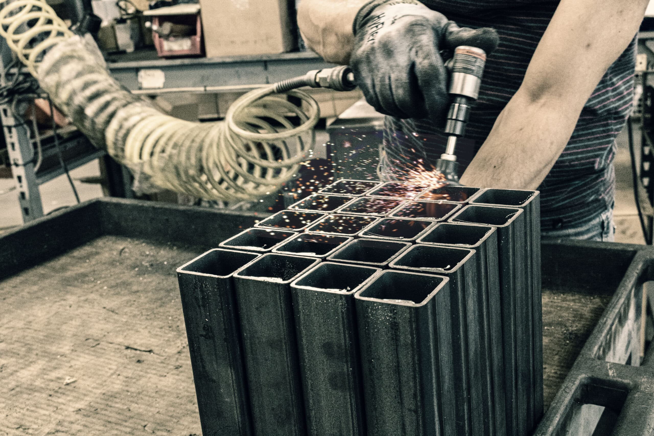 FC Safety employee using a grinder on steel legs for a confined-space tripod
